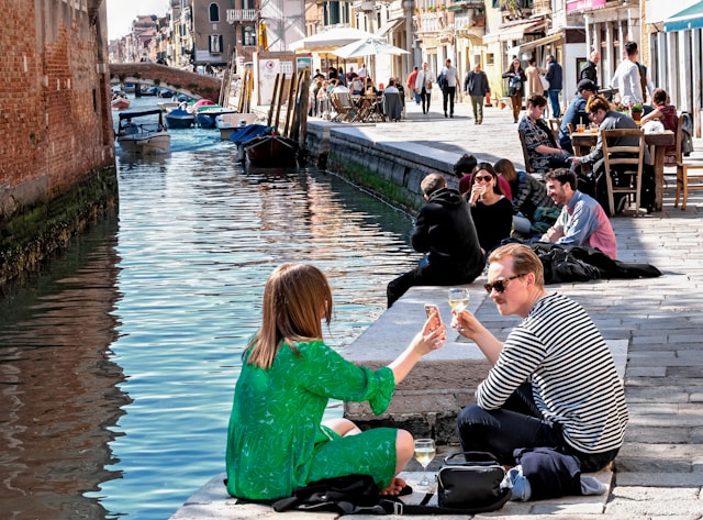 A young couple drinking wine in the sun in the Cannaregio district in Venice