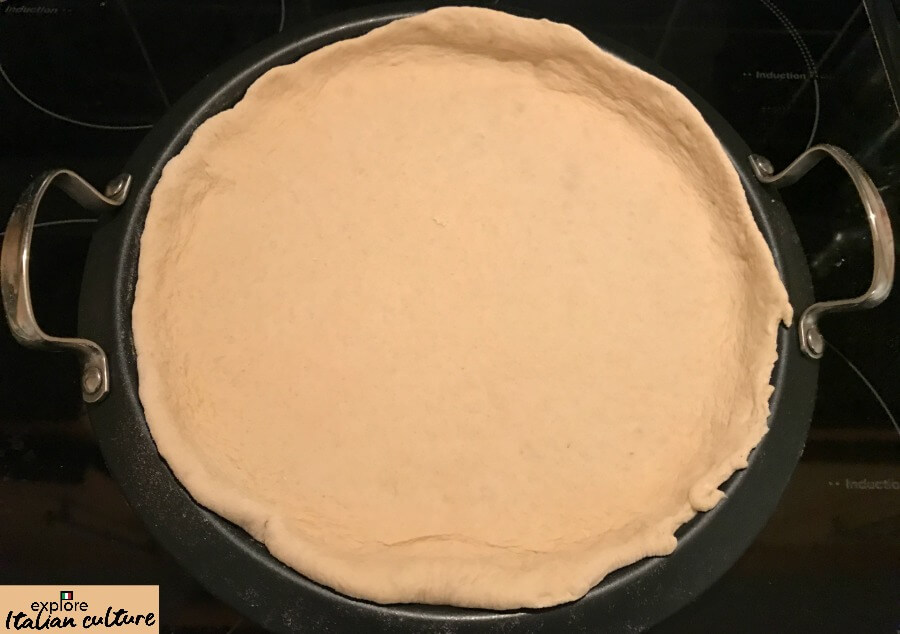 Pizza dough in a pizza pan before cooking