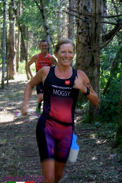 Running downhill through a forest at the Bologna swimrun