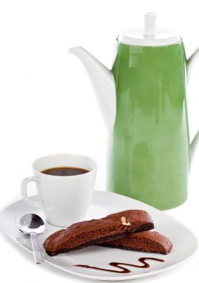 Chocolate biscotti Chocolate biscotti on a white plate with a cup of coffee and a coffee pot