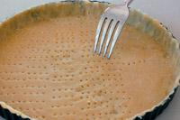 Pricking the Italian cheesecake pastry base with a fork