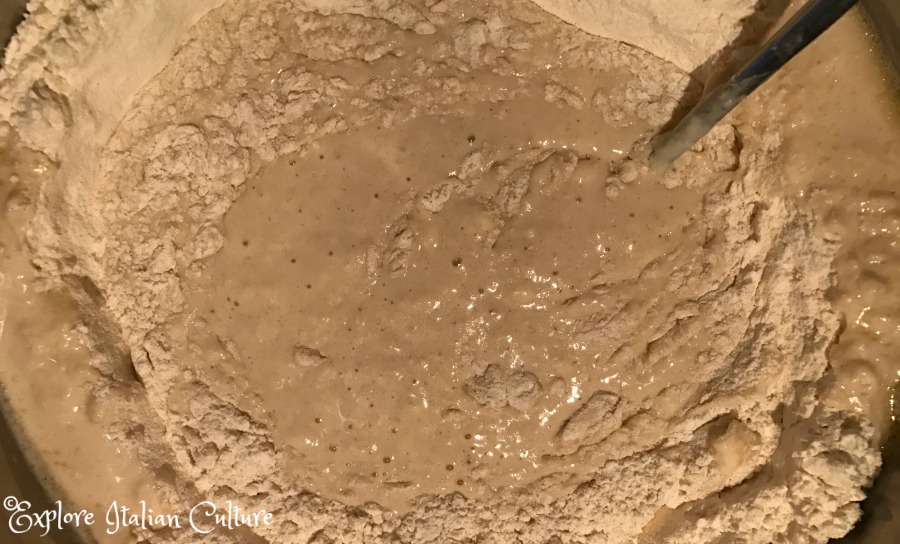 Combining the liquid with the flour.