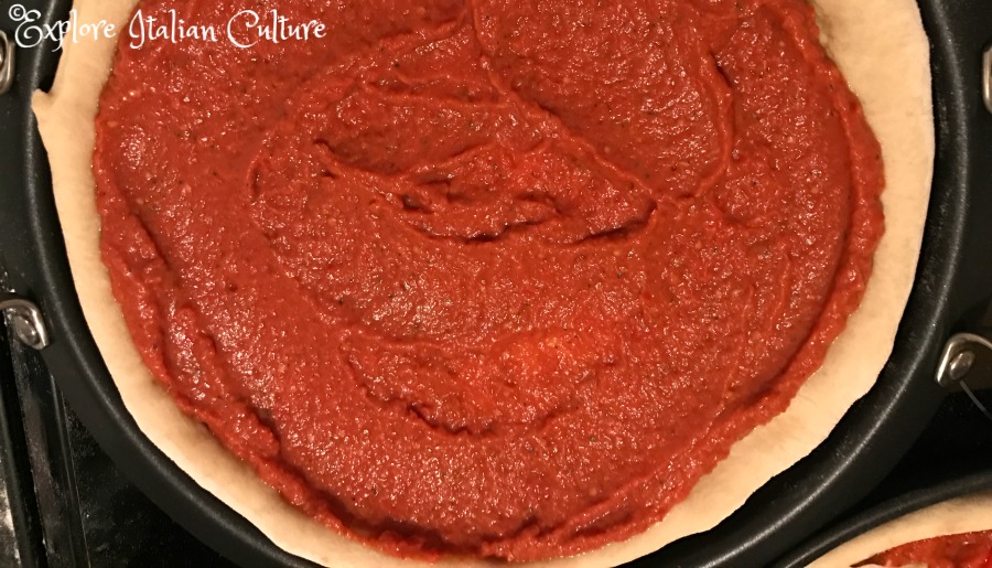 Pizza base with tomato sauce.