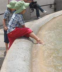 Cute children may get away with dipping their toes in a fountain - but adults definitely won't! Cute children dip their toes in a fountain in Rome.