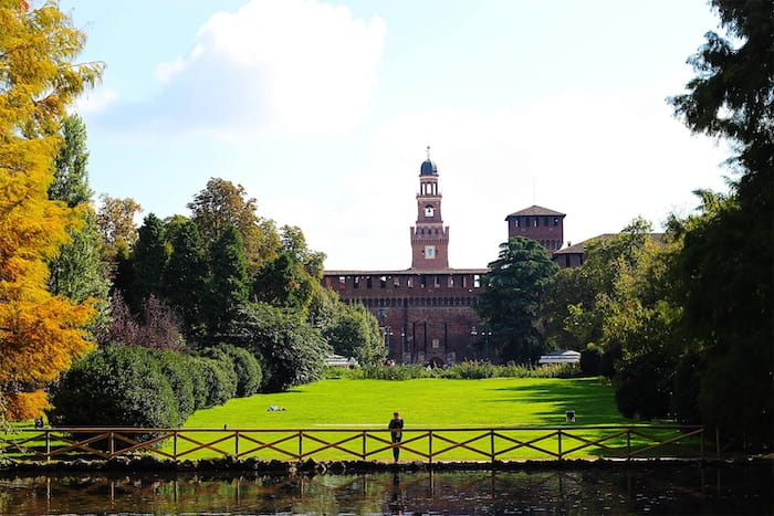 A view of Sempione Park in Milan with a green lawn in the foreground A view of Sempione Park in Milan with a green lawn in the foreground
