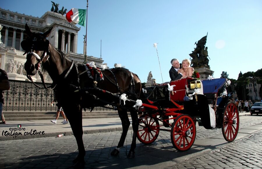 A wedding couple in a horse-drawn carriage, outside the Campodoglio in Rome