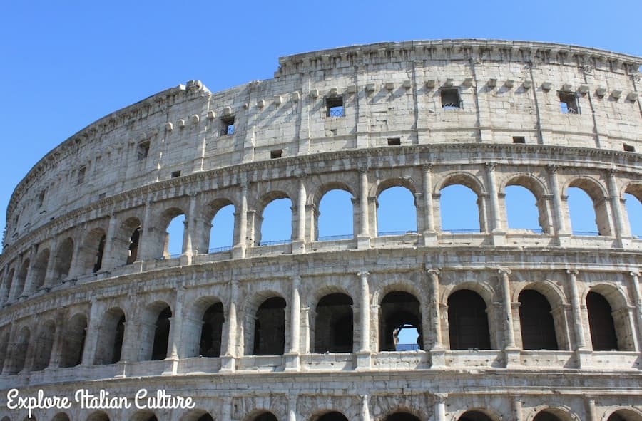 The Colosseum in Rome with bright blue sky in the background.